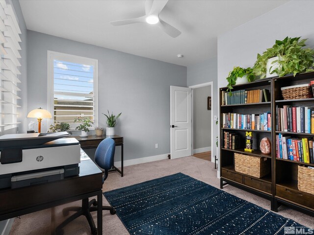 carpeted home office featuring a ceiling fan and baseboards