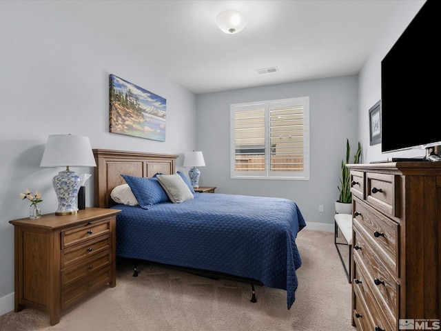 bedroom featuring light colored carpet and baseboards