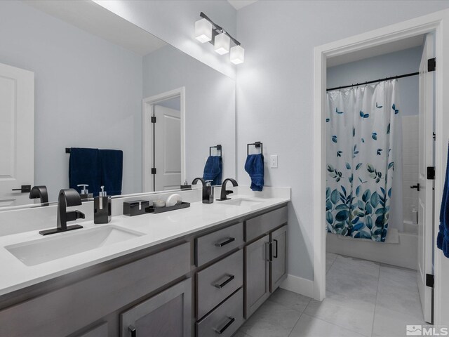 bathroom with double vanity, shower / bath combination with curtain, tile patterned flooring, and baseboards