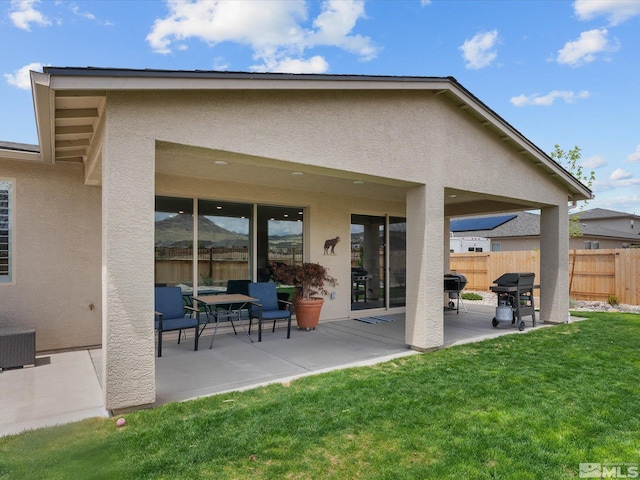 rear view of house featuring stucco siding and a patio area