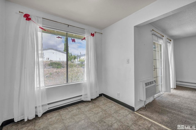 unfurnished room with plenty of natural light, a wall mounted AC, baseboards, and a textured ceiling