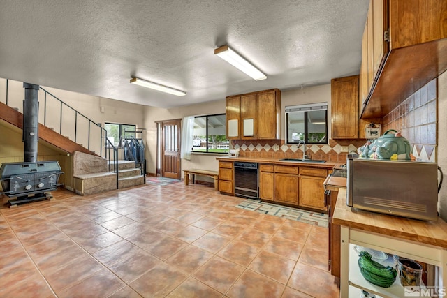 1131 Linda Anne Ct, Gardnerville, NV 89410 - kitchen with a sink, brown cabinetry, tasteful backsplash, light tile patterned floors, and a textured ceiling
