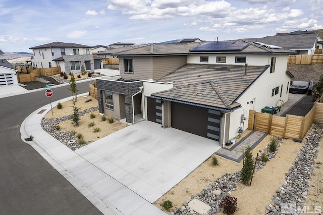 5410 Cactus Quartz Ct, Sparks, NV 89436 - view of front of house with solar panels, an attached garage, stucco siding, concrete driveway, and a residential view