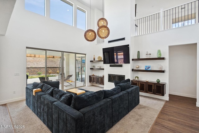5410 Cactus Quartz Ct, Sparks, NV 89436 - living area with a towering ceiling, healthy amount of natural light, wood finished floors, a glass covered fireplace, and baseboards