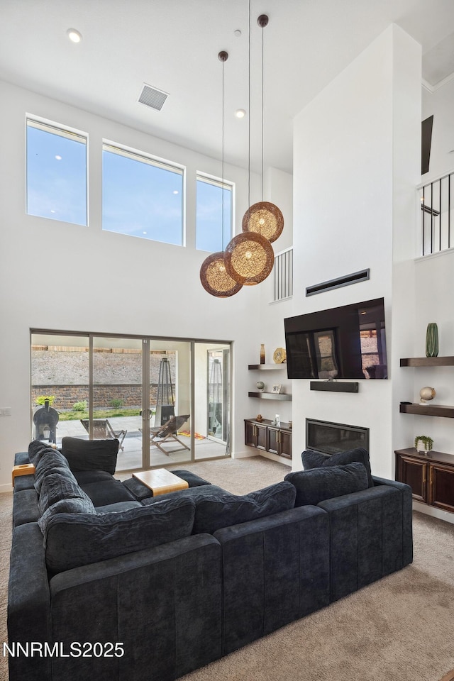 5410 Cactus Quartz Ct, Sparks, NV 89436 - carpeted living area with a towering ceiling, a glass covered fireplace, baseboards, and recessed lighting