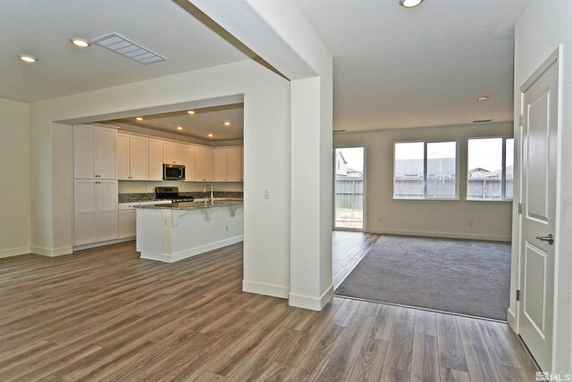 2091 Forest Grove Ln, Sparks, NV 89436 - kitchen featuring stainless steel appliances, open floor plan, dark wood-style floors, a kitchen bar, and recessed lighting