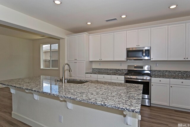 2091 Forest Grove Ln, Sparks, NV 89436 - kitchen featuring stainless steel appliances, a sink, dark wood-style flooring, a breakfast bar, and white cabinets