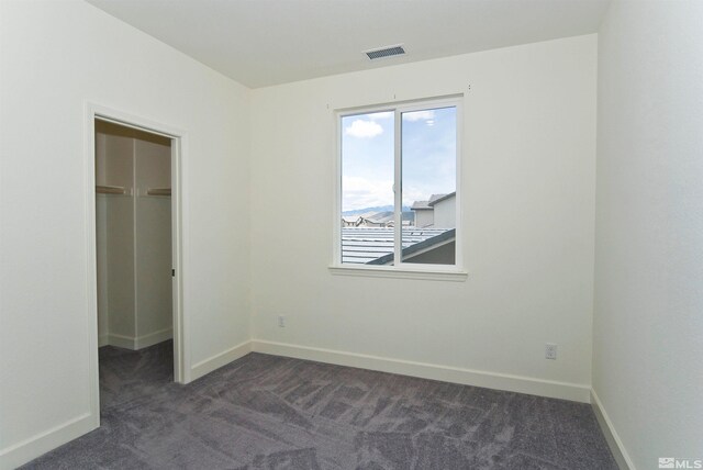 2091 Forest Grove Ln, Sparks, NV 89436 - unfurnished bedroom featuring a walk in closet, dark colored carpet, baseboards, and a closet