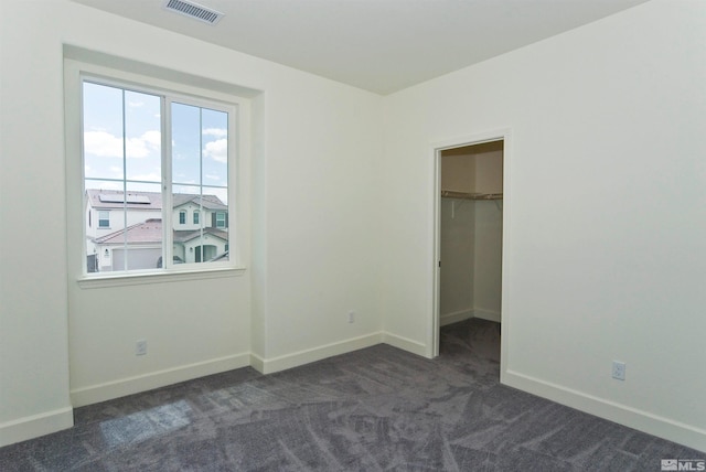 2091 Forest Grove Ln, Sparks, NV 89436 - unfurnished bedroom with multiple windows, dark colored carpet, baseboards, and a spacious closet