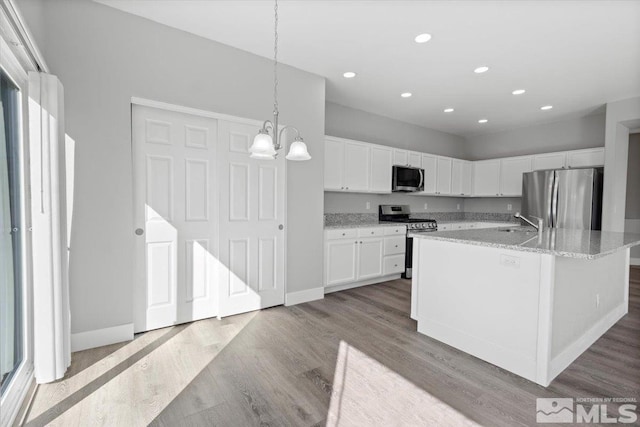 8952 Mahon Dr, Reno, NV 89506 - kitchen featuring stainless steel appliances, white cabinetry, wood finished floors, a sink, and a chandelier