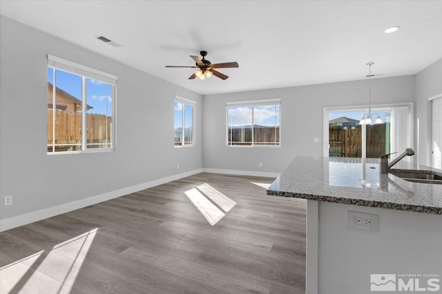 8952 Mahon Dr, Reno, NV 89506 - unfurnished living room featuring a sink, a chandelier, wood finished floors, a ceiling fan, and baseboards