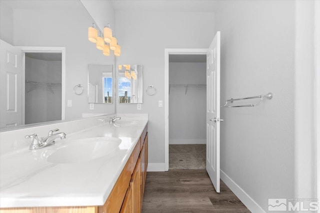 8952 Mahon Dr, Reno, NV 89506 - full bathroom featuring a spacious closet, double vanity, baseboards, and wood finished floors