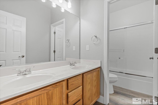 8952 Mahon Dr, Reno, NV 89506 - full bath featuring wood finished floors, toilet, double vanity, and shower / bath combination with glass door