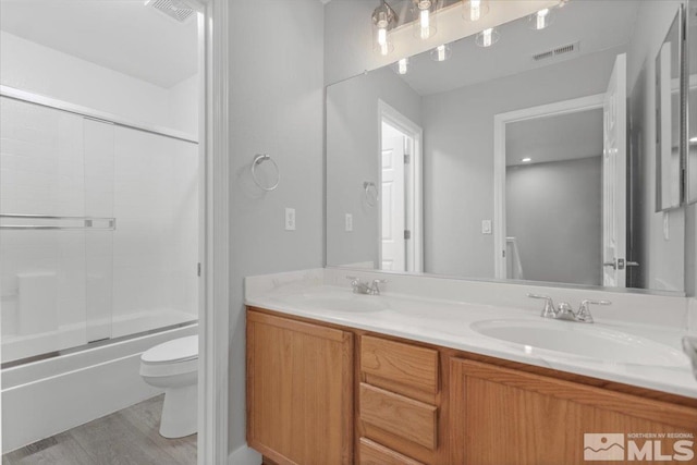 8952 Mahon Dr, Reno, NV 89506 - full bathroom featuring toilet, wood finished floors, double vanity, and combined bath / shower with glass door