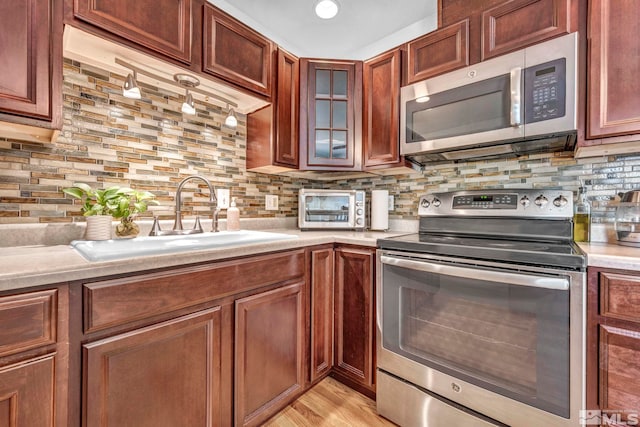 20 E Devere Way, Sparks, NV 89431 - kitchen with appliances with stainless steel finishes, a sink, light countertops, tasteful backsplash, and glass insert cabinets