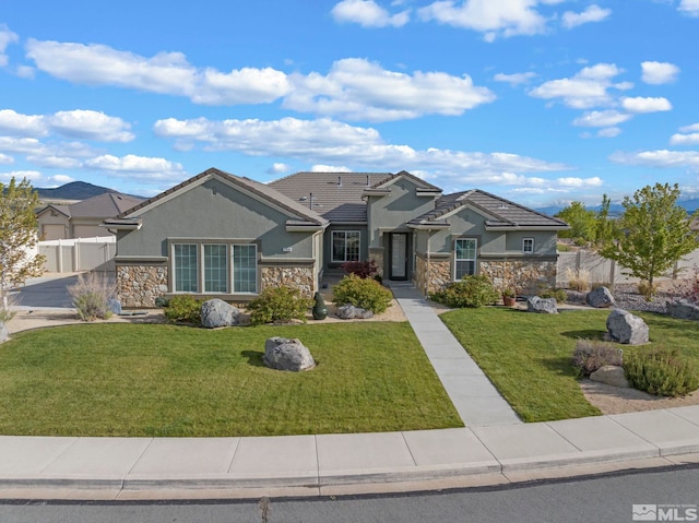 view of front of property with stone siding, stucco siding, a front lawn, and a tile roof