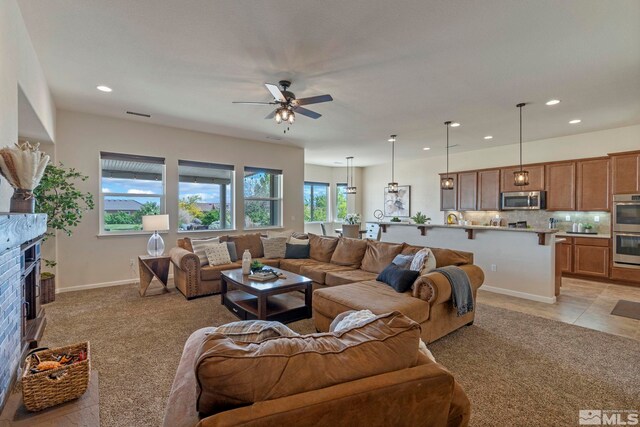 living area with recessed lighting, ceiling fan, light colored carpet, and baseboards