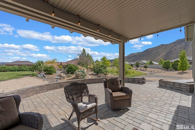 view of patio featuring a mountain view and fence