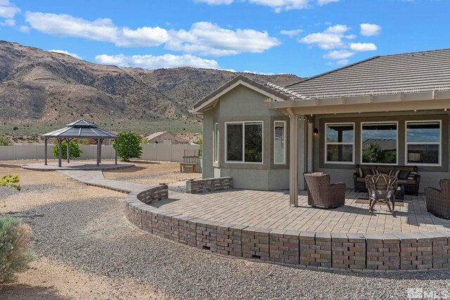 view of patio with a gazebo, fence, and a mountain view
