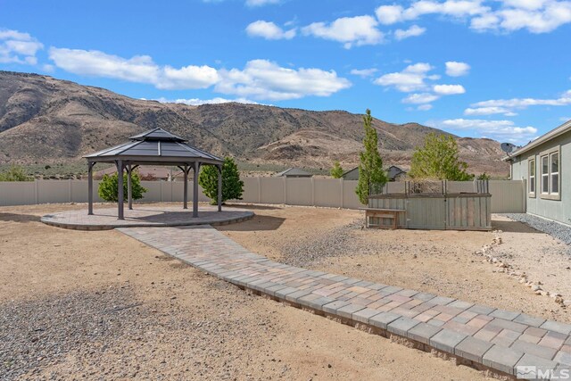 fenced backyard featuring a gazebo, a mountain view, and a patio