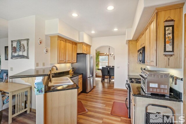 2045 Flint Rd, Reno, NV 89521 - kitchen featuring a sink, stainless steel appliances, a peninsula, light wood-style floors, and a chandelier