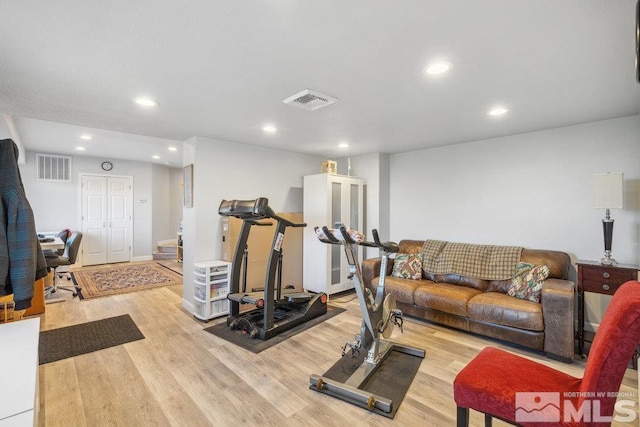 exercise area with light wood finished floors and recessed lighting
