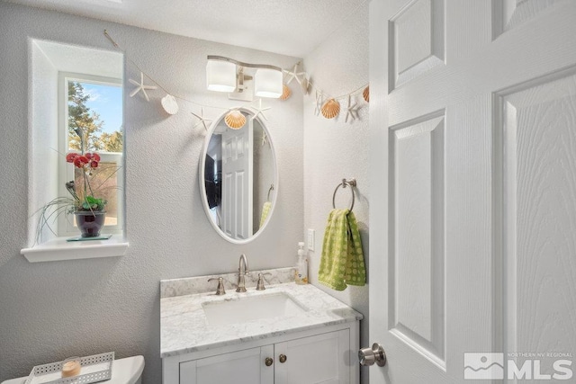 half bath featuring vanity and toilet