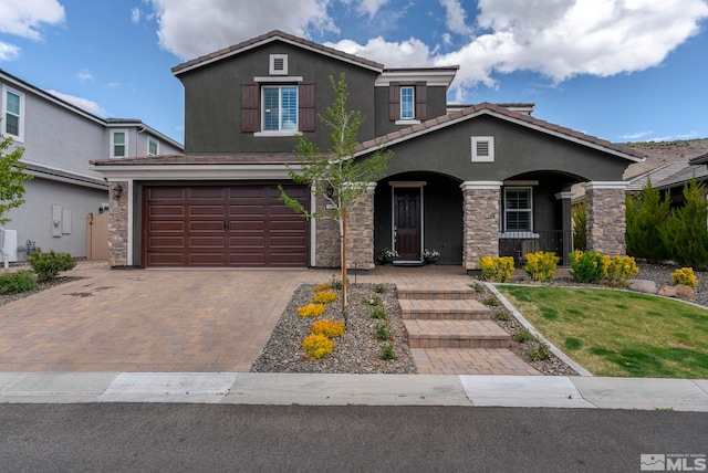 3325 Show Jumper Ln, Reno, NV 89521 - traditional-style home with covered porch, a garage, stucco siding, decorative driveway, and stone siding