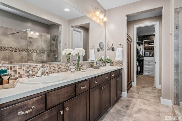 3325 Show Jumper Ln, Reno, NV 89521 - bathroom featuring a tile shower, backsplash, a spacious closet, double vanity, and baseboards