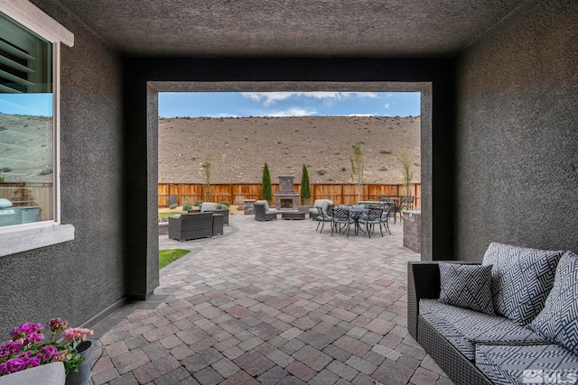 3325 Show Jumper Ln, Reno, NV 89521 - view of patio featuring an outdoor living space with a fireplace, outdoor dining space, and fence