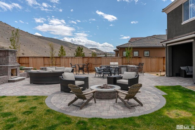 3325 Show Jumper Ln, Reno, NV 89521 - view of patio / terrace with an outdoor living space with a fireplace, a fenced backyard, and area for grilling