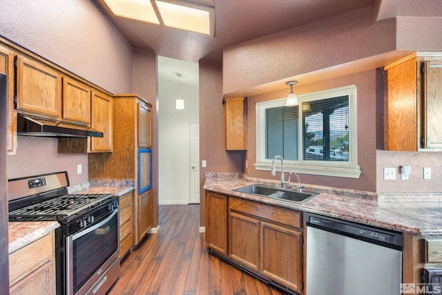 123 River Village Cir, Dayton, NV 89403 - kitchen with stainless steel appliances, a sink, under cabinet range hood, dark wood finished floors, and hanging light fixtures