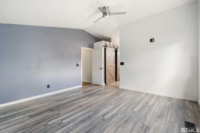 123 River Village Cir, Dayton, NV 89403 - empty room featuring a ceiling fan, wood finished floors, baseboards, lofted ceiling, and a barn door