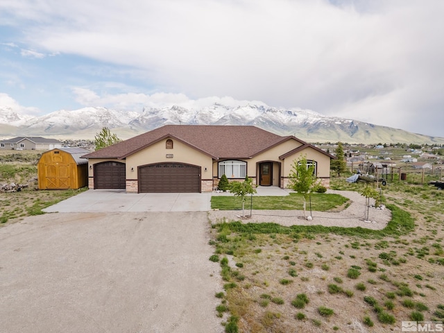 748 Thistle Dr, Spring Creek, NV 89815 - view of front of home featuring stucco siding, a mountain view, a garage, and concrete driveway