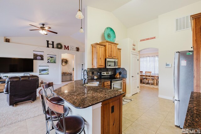 748 Thistle Dr, Spring Creek, NV 89815 - kitchen featuring stainless steel appliances, arched walkways, a sink, a ceiling fan, and light tile patterned floors