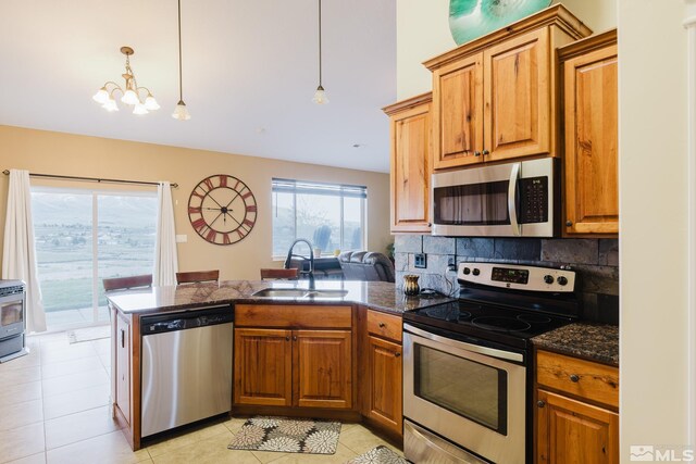 748 Thistle Dr, Spring Creek, NV 89815 - kitchen with stainless steel appliances, a sink, a peninsula, backsplash, and brown cabinetry