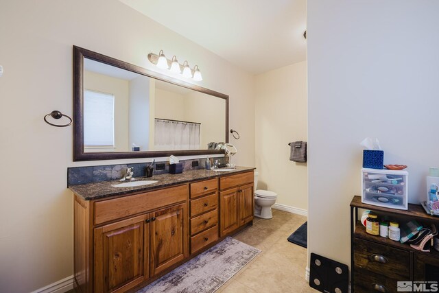 748 Thistle Dr, Spring Creek, NV 89815 - bathroom with double vanity, toilet, tile patterned floors, and baseboards