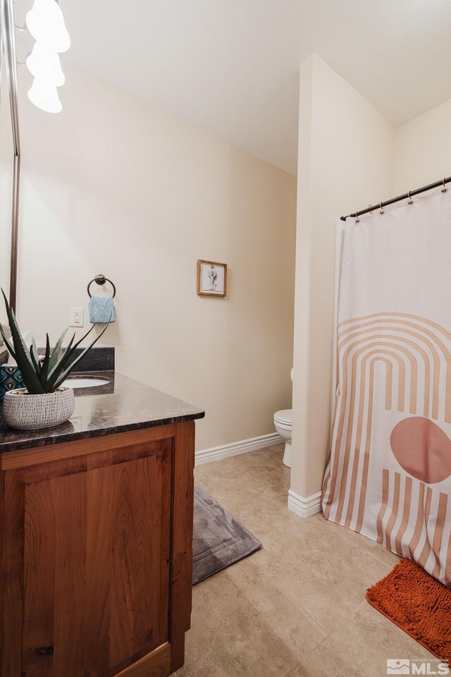 748 Thistle Dr, Spring Creek, NV 89815 - bathroom with vanity, toilet, baseboards, and a shower with curtain