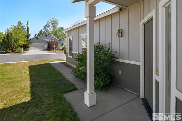 10010 Purple Sage Dr, Reno, NV 89506 - property entrance with board and batten siding, a yard, and a surveillance system