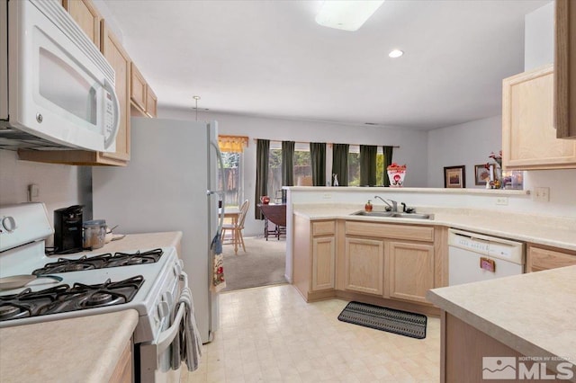 10010 Purple Sage Dr, Reno, NV 89506 - kitchen featuring white appliances, a sink, light brown cabinetry, light countertops, and a peninsula
