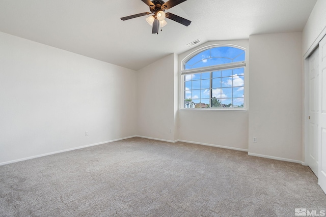 unfurnished bedroom with lofted ceiling, carpet, baseboards, a closet, and ceiling fan