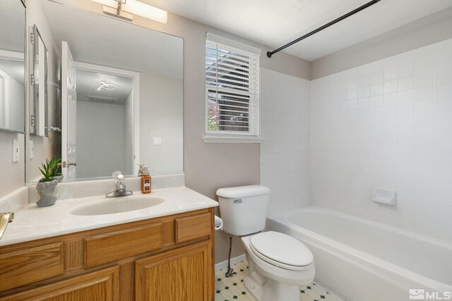 bathroom with toilet, vanity, bathtub / shower combination, baseboards, and tile patterned floors