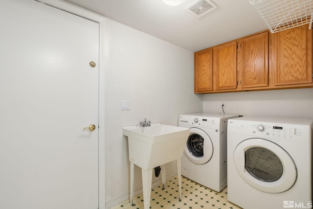 clothes washing area featuring cabinet space, washer and dryer, and light flooring