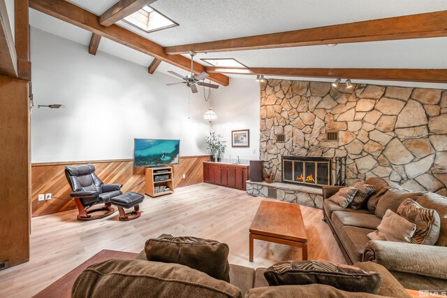 12565 Creek Crest Dr, Reno, NV 89511 - living area with a wainscoted wall, wood finished floors, a ceiling fan, a fireplace, and rail lighting