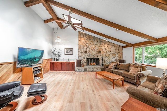 12565 Creek Crest Dr, Reno, NV 89511 - living area featuring a ceiling fan, light wood-style flooring, a stone fireplace, and a wainscoted wall