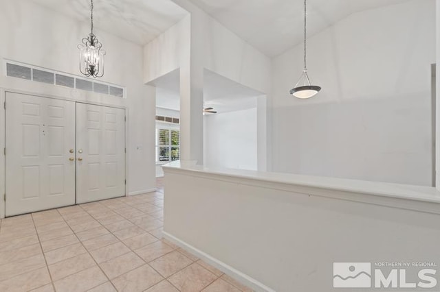 5979 Hidden Highlands Dr, Reno, NV 89502 - foyer entrance featuring light tile patterned flooring, high vaulted ceiling, a chandelier, and baseboards