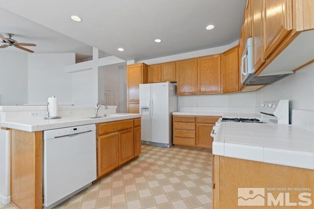 5979 Hidden Highlands Dr, Reno, NV 89502 - kitchen featuring white appliances, light flooring, a sink, a ceiling fan, and an island with sink