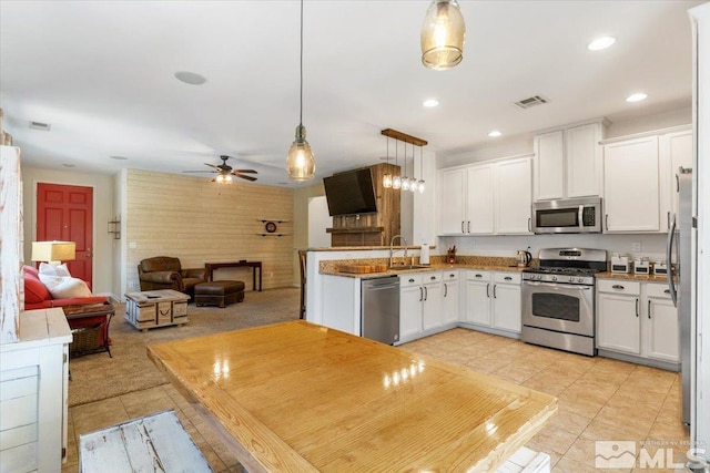 9185 Raytheon Ct, Reno, NV 89506 - kitchen with stainless steel appliances, light tile patterned floors, a sink, white cabinets, and recessed lighting