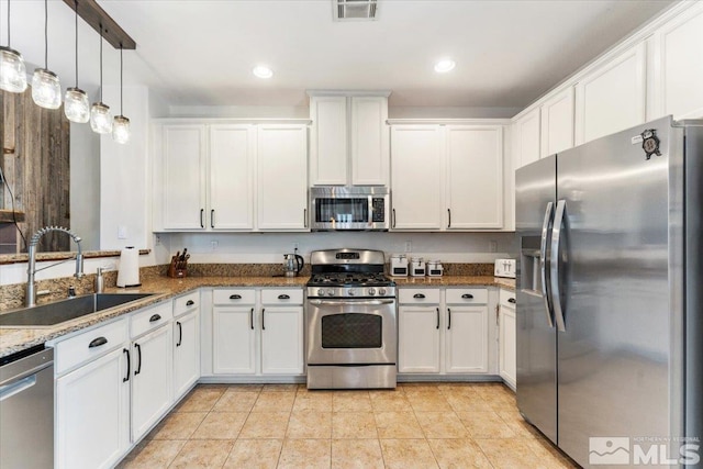 9185 Raytheon Ct, Reno, NV 89506 - kitchen with stainless steel appliances, a sink, white cabinets, stone countertops, and light tile patterned floors
