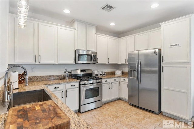 9185 Raytheon Ct, Reno, NV 89506 - kitchen featuring stainless steel appliances, a sink, white cabinets, and recessed lighting